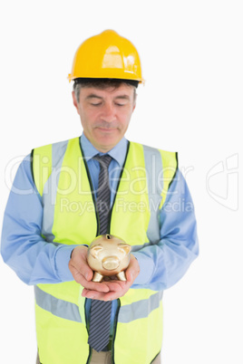 Architect holding a piggy bank