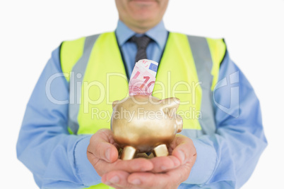 Man in vest holding a piggy-bank