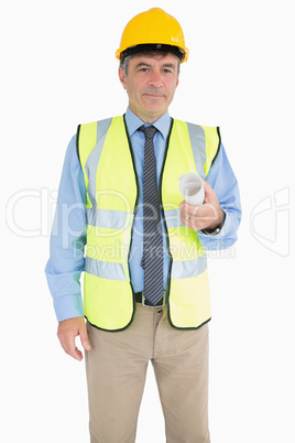 Architect in vest and helmet holding a plan