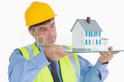 Architect holding a glass slide with miniature house