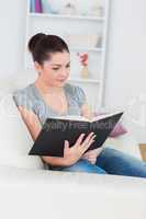 Woman sitting on the couch and reading a book