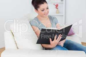 Woman sitting in the living room on the couch and reading