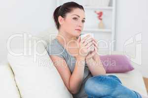 Woman sitting on the couch and holding a mug