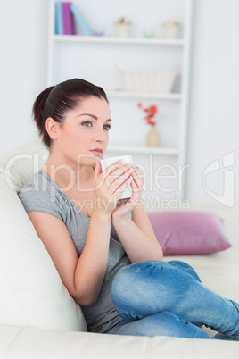 Thoughtful woman sitting on the couch