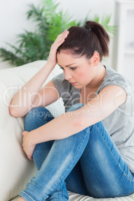 Unhappy woman sitting on the couch in the living room