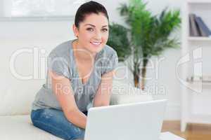 Woman using a laptop while sitting on the couch