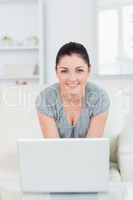 Woman sitting on the couch and using a laptop