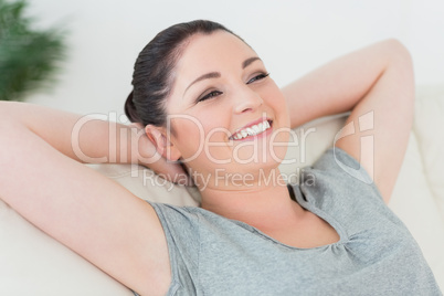 Carefree woman on the couch leaning back