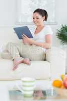 Sitting woman in the living room using a tablet pc