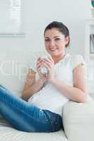 Woman sitting on the couch and holding a cup