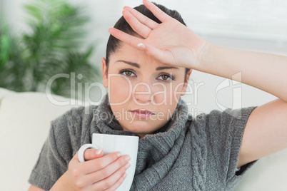 Ill woman sitting on the couch in a living room