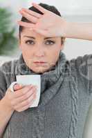 Woman sitting on the couch and feeling ill