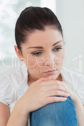 Sad looking woman sitting on the couch