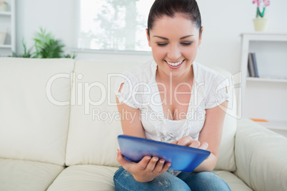 Smiling woman using a tablet pc on the couch