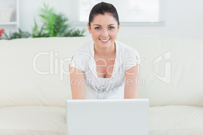 Woman sitting on the couch and using the laptop
