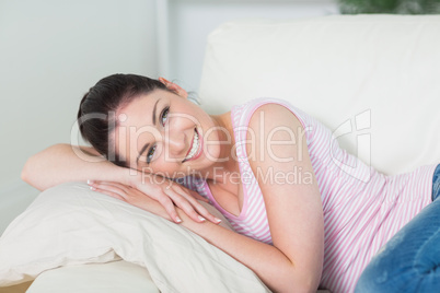 Smiling and relaxing woman lying on a couch