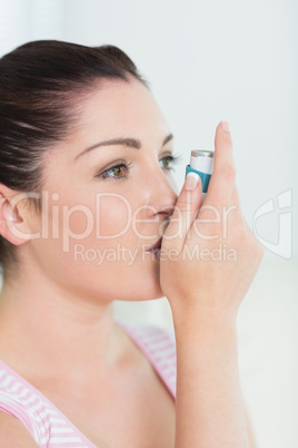 Woman with asthma using an asthma inhaler