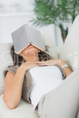 Brunette sleeping with her book on the head