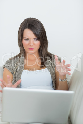 Woman looking wary of laptop