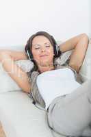 Smiling woman using headphone to listen music