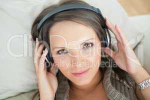Calm woman using headphones to listen music
