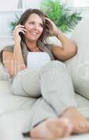 Woman lying on sofa and calling