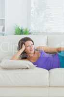 Calm brunette lying on sofa