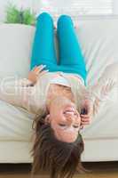 Smiling woman with legs up on couch phoning