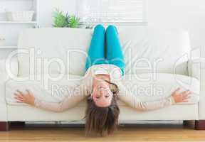 Funny woman lying upside down on sofa
