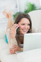 Smiling woman calling in front of her laptop