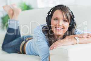 Woman listening music looking happy on sofa