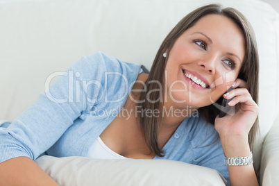Smiling woman lying on sofa and calling Smiling woman lying on sofa and calling