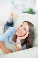 Happy woman  lying on sofa looking up