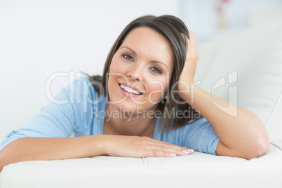 Smiling woman lying on sofa