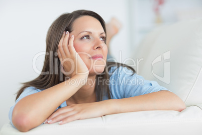 Smiling brunette lying on sofa