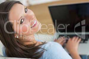 Brunette looking up from using laptop