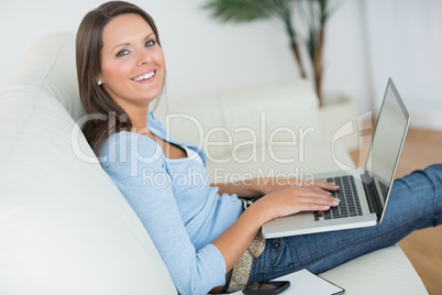 Woman sitting on sofa with her laptop