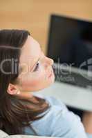 Woman looking away from laptop