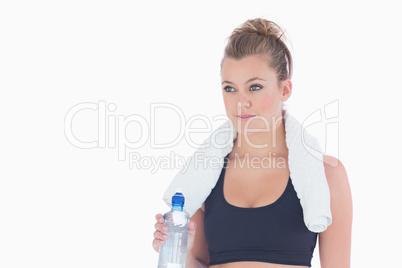 Woman standing holding a bottle of water and a towel