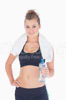 Woman standing hand on hips with bottled water