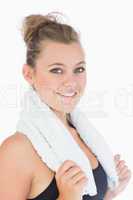 Woman standing and smiling with towel over shoulders