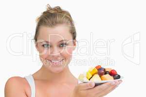 Woman holding up a plate fruits
