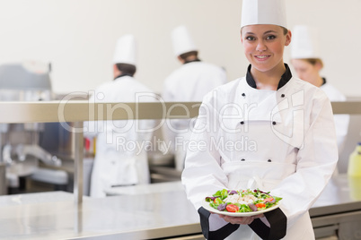 Smiling chef  showing her salad
