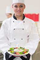 Cheerful chef showing her salad