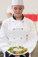 Cheerful chef looking at her salad