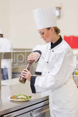 Chef cooking a salad with pepper