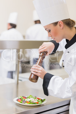 Chef preparing a salad with pepper