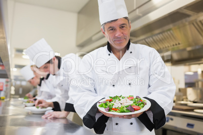 Cheerful chef presenting his salad