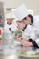 Culinary class making salads as teacher is supervising