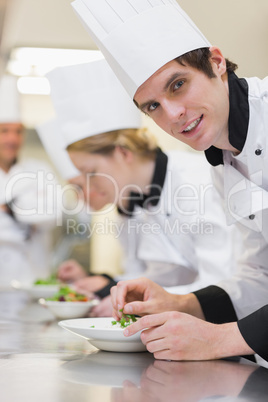 Chef looking up from preparing salad